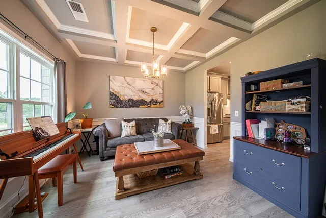 a living room with furniture a flat screen tv and a window