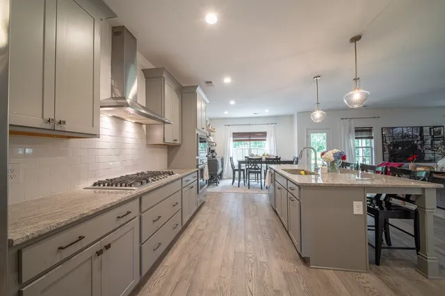 a kitchen with stainless steel appliances granite countertop a lot of counter space and wooden floors