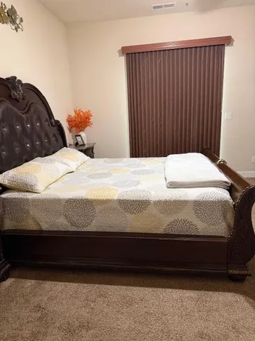 a bedroom with a bed and a large window