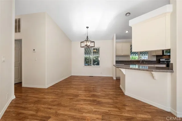 a view of a kitchen with kitchen island a sink wooden floor and a counter top space