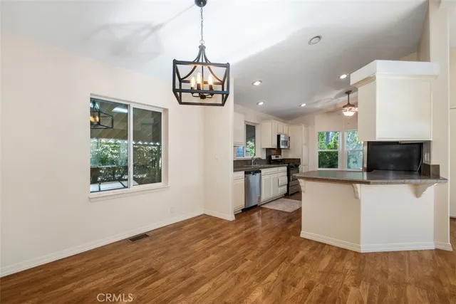 a view of a kitchen with kitchen island wooden floor center island and stainless steel appliances