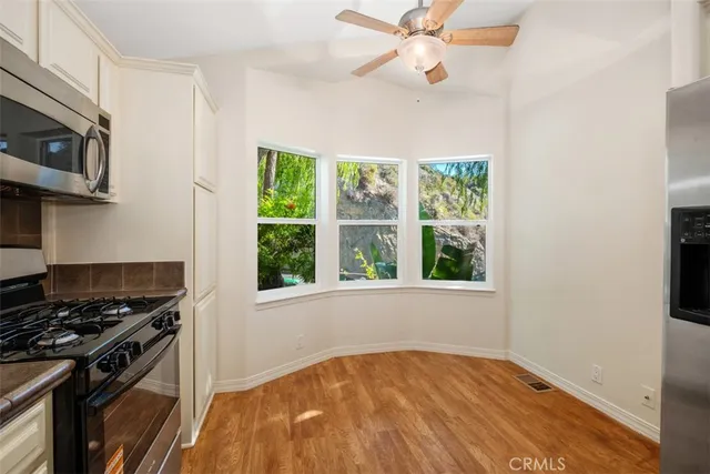 a kitchen with a stove a microwave and window