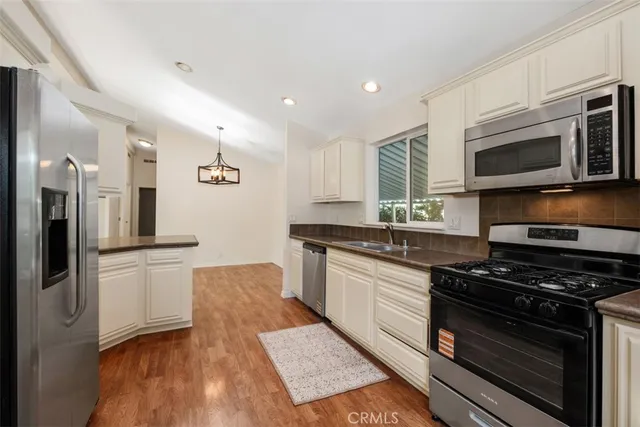 a kitchen with stainless steel appliances a stove a sink and a microwave