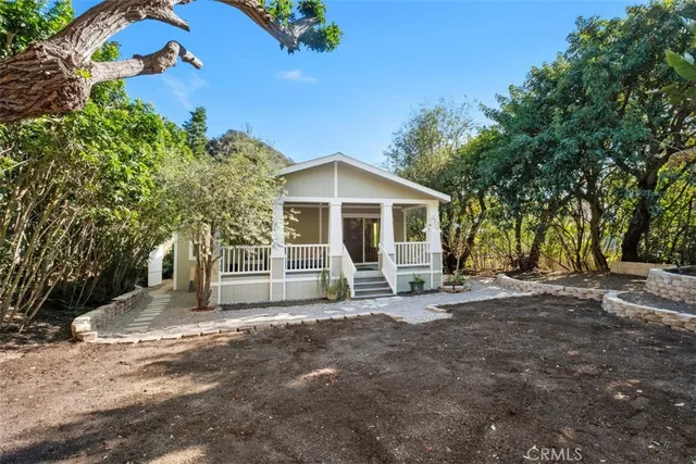 a view of a house with a large tree and a yard