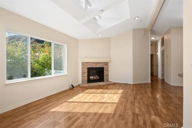 a view of an empty room with glass door and wooden floor