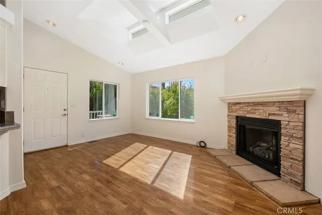 a view of empty room with fireplace and wooden floor