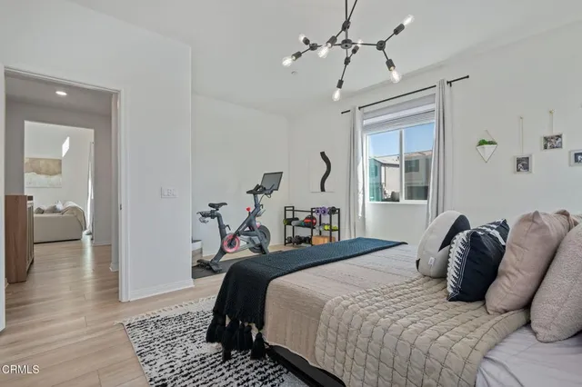 a bedroom with bed and a chandelier
