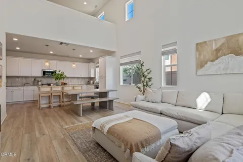a living room with furniture and view of kitchen