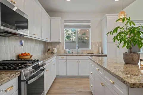 a kitchen with sink a window and potted plant