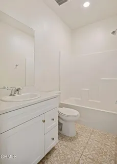 a bathroom with a granite countertop toilet a sink and a bathtub