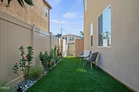 a view of a chair and table in the back yard of the house