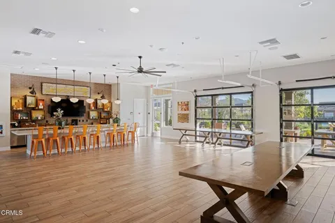 a dining room with wooden floor a glass table and chairs