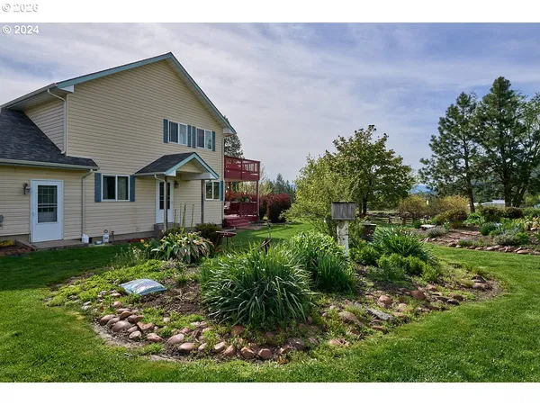 a front view of a house with a yard and green space