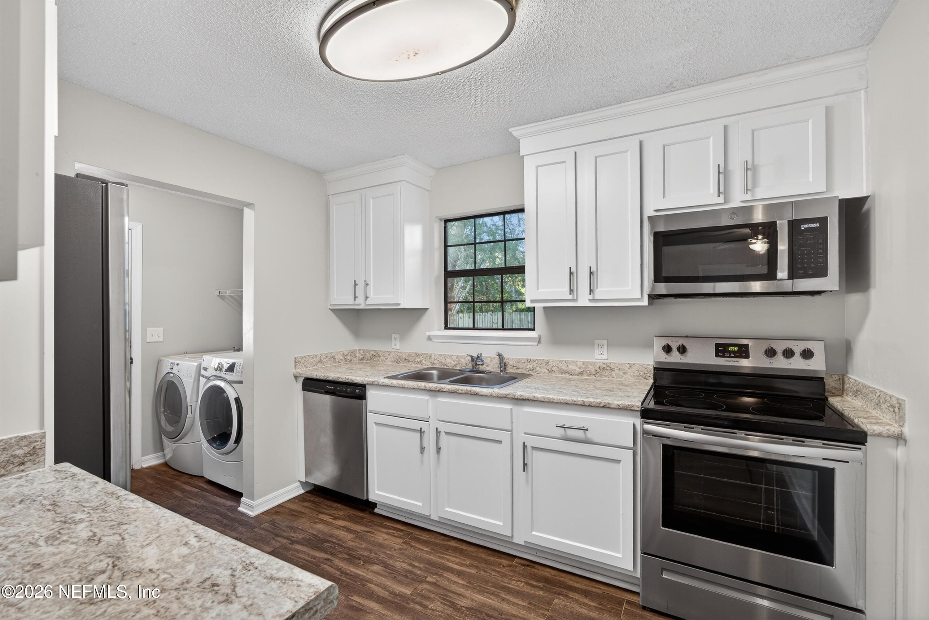 591 Julia Street St. Augustine, FL 32084 - Photo 7 of 25 a kitchen with a sink stove and microwave