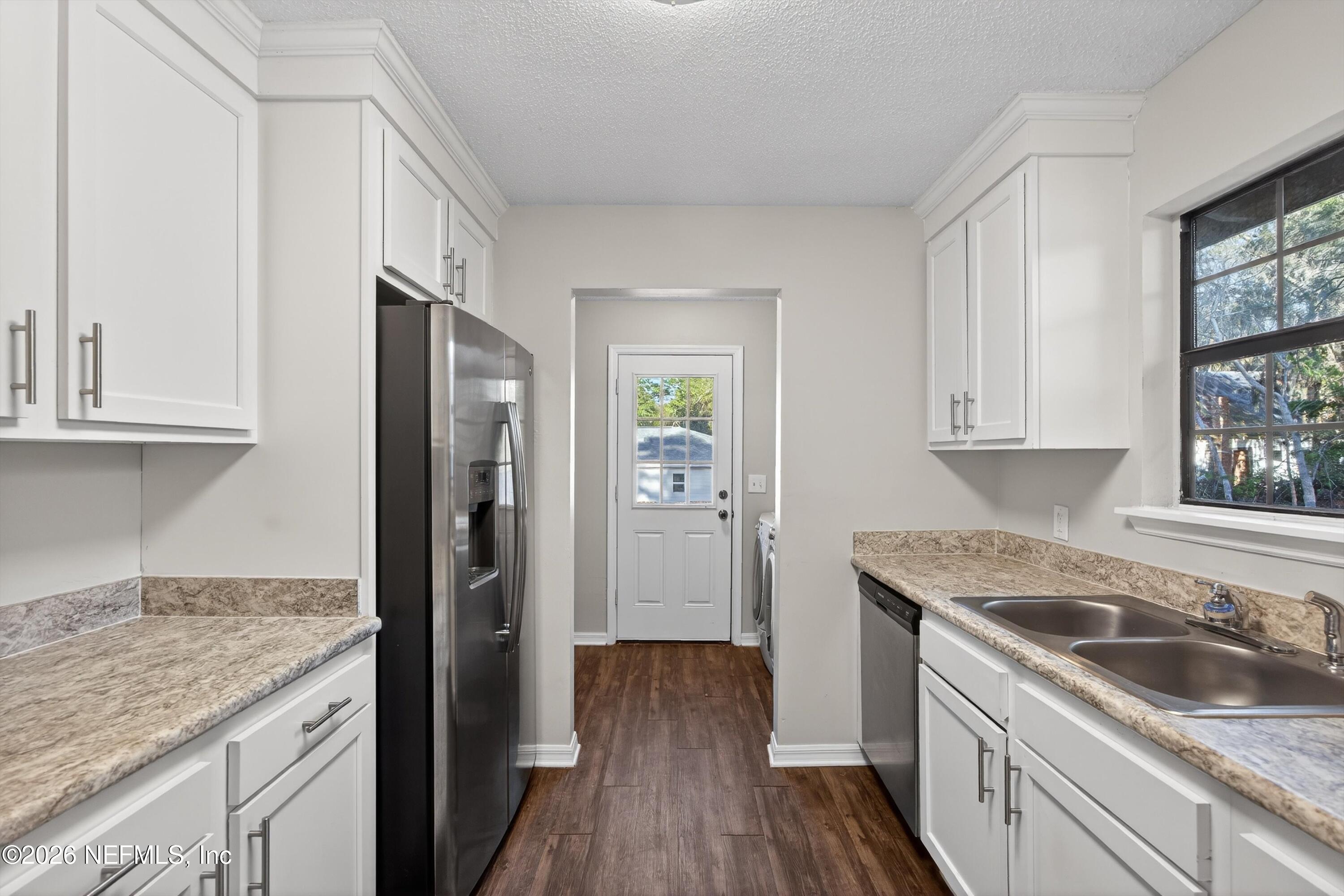 591 Julia Street St. Augustine, FL 32084 - Photo 8 of 25 a kitchen with a granite countertop sink a refrigerator and cabinets