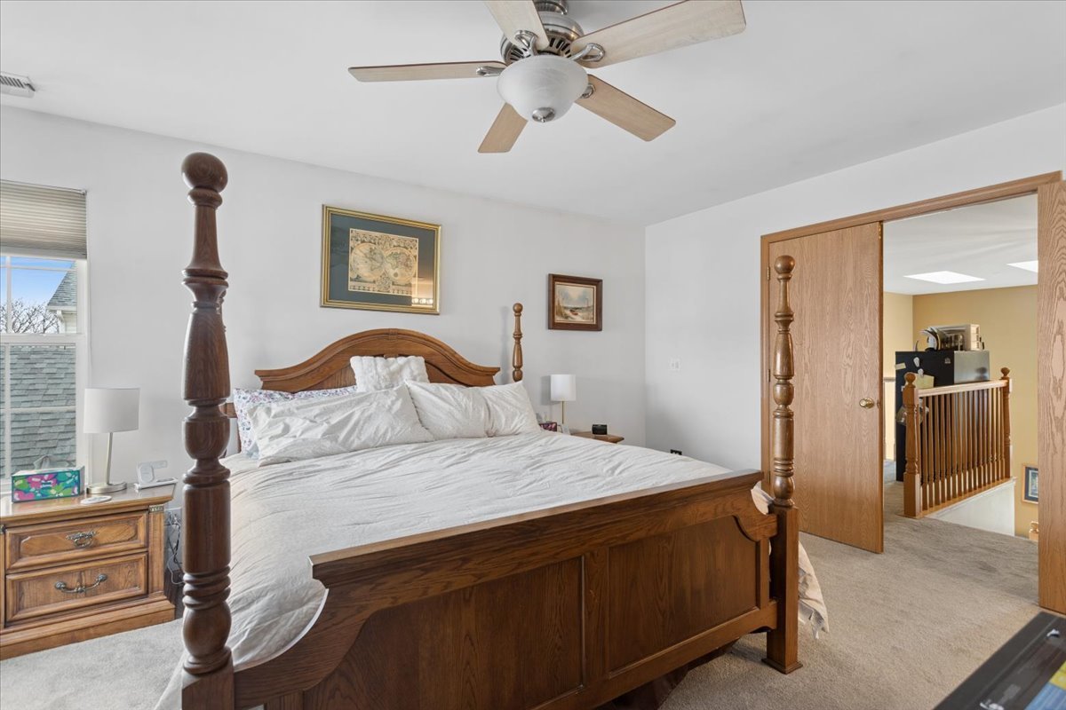 14902 West Victoria Crossing Lockport, IL 60441 - Photo 11 of 23 a bedroom with a bed and a chandelier