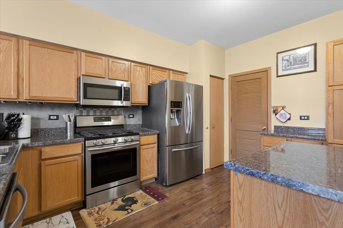 14902 West Victoria Crossing Lockport, IL 60441 - Photo 6 of 23 a kitchen with stainless steel appliances granite countertop a refrigerator stove and microwave