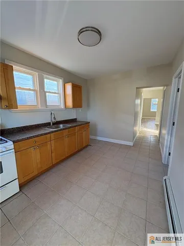 a large white kitchen with a sink and cabinets