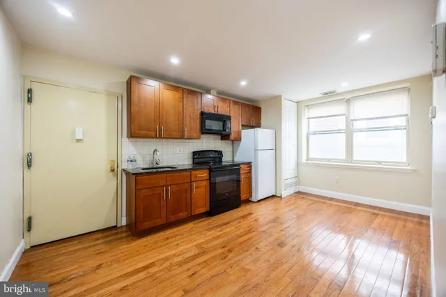 a kitchen with granite countertop a refrigerator and a stove top oven