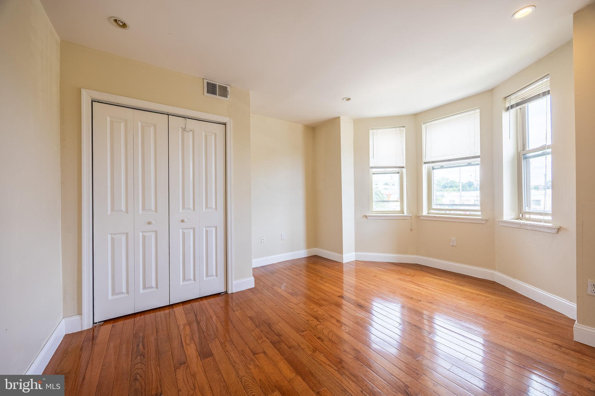 4706 Chestnut Street, Unit 1A Philadelphia, PA 19139 - Photo 7 of 18 a view of an empty room with wooden floor and a window