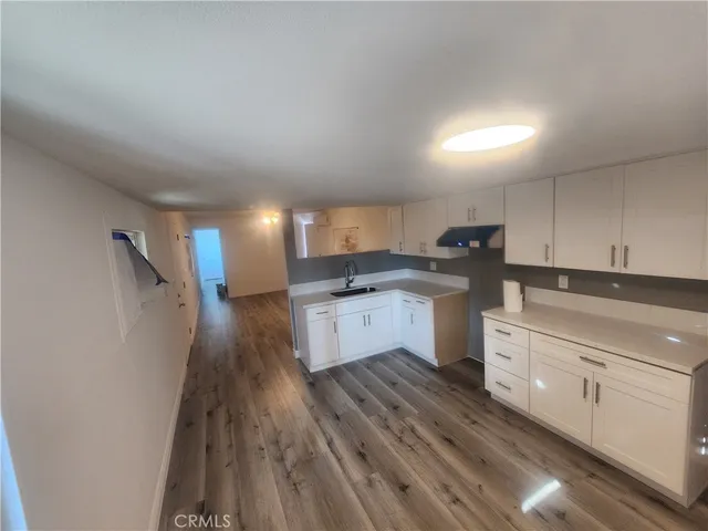 a kitchen with white cabinets stainless steel appliances and a sink