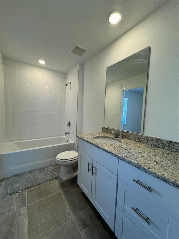 4346 Restful Fallow Cove St. Cloud, FL 34772 - Photo 13 of 20 a bathroom with a granite countertop toilet a sink and a mirror