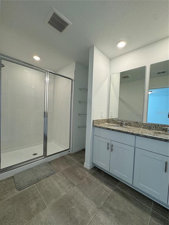 4346 Restful Fallow Cove St. Cloud, FL 34772 - Photo 16 of 20 a bathroom with granite countertop shower and a sink