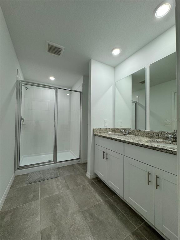 4346 Restful Fallow Cove St. Cloud, FL 34772 - Photo 18 of 20 a bathroom with a granite countertop sink mirror and shower