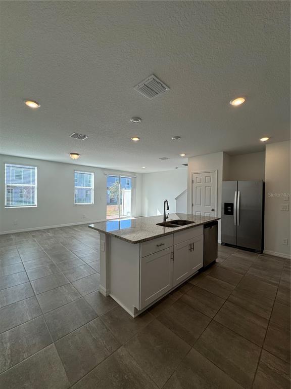 4346 Restful Fallow Cove St. Cloud, FL 34772 - Photo 5 of 20 a large white kitchen with a sink and dishwasher a refrigerator with white cabinets