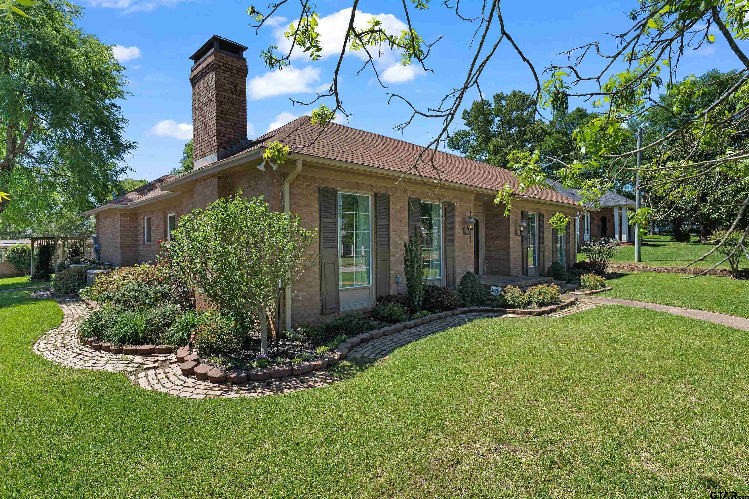 a front view of a house with a yard and potted plants