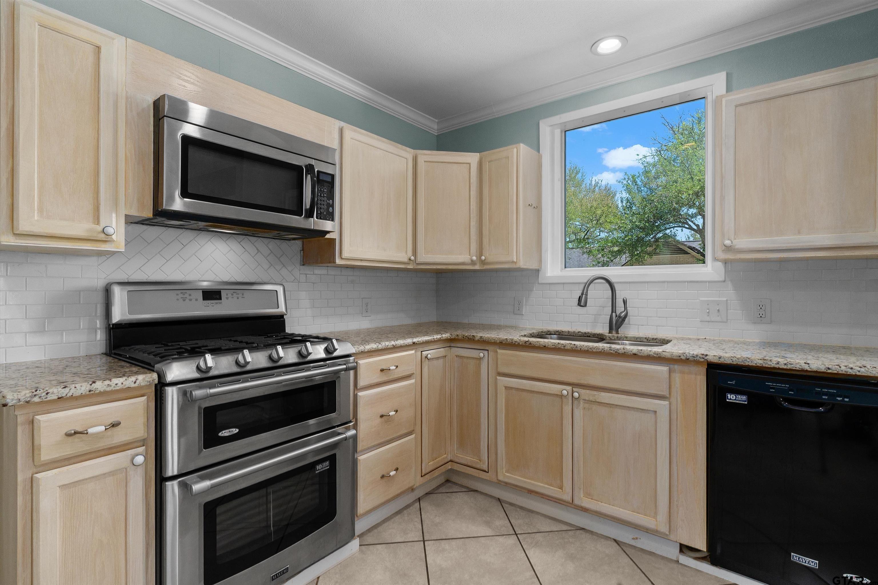 326 East Main Street Henderson, TX 75652 - Photo 13 of 35 a kitchen with white cabinets appliances and a window