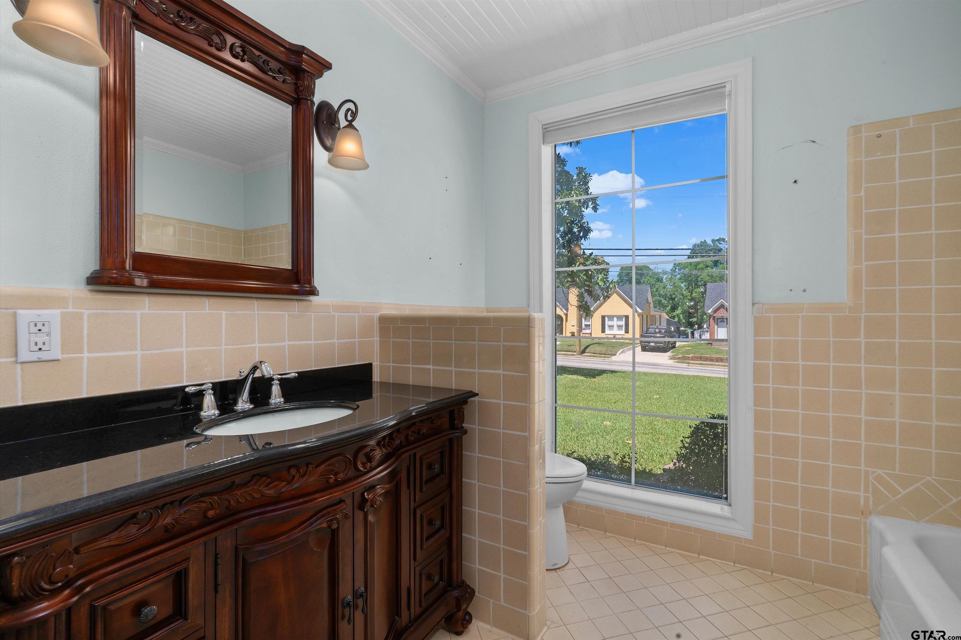 326 East Main Street Henderson, TX 75652 - Photo 23 of 35 a bathroom with a granite countertop sink a mirror and a shower