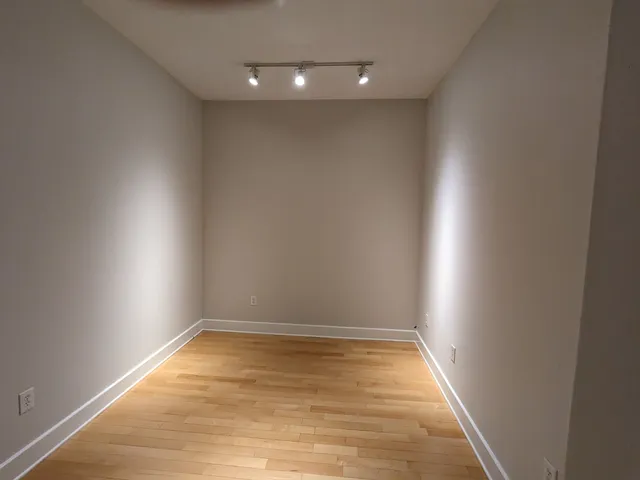 an empty room with a ceiling fan and carpet
