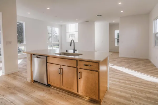 a kitchen with stainless steel appliances granite countertop a sink and a refrigerator