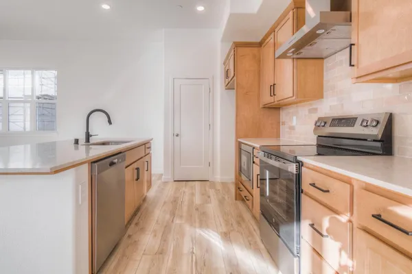 a kitchen with granite countertop a sink stove and cabinets