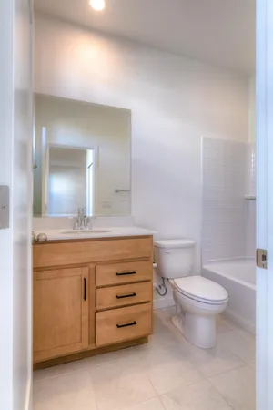 a bathroom with a granite countertop toilet a sink and a mirror
