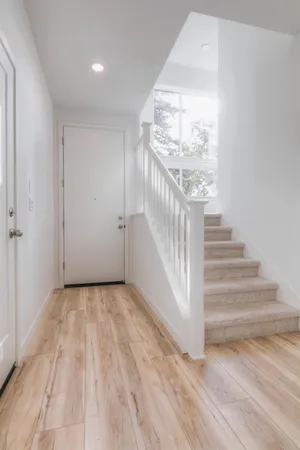 a view of a hallway with wooden floor and staircase