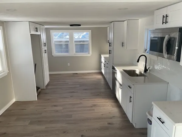 a kitchen with granite countertop a sink and a refrigerator