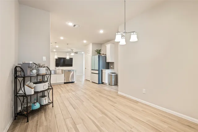 a view of a kitchen with wooden floor and stainless steel appliances