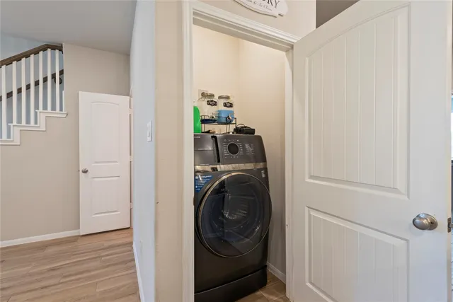 a utility room with wooden floor washer and dryer