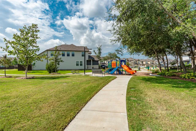 a view of a house with a big yard and large trees