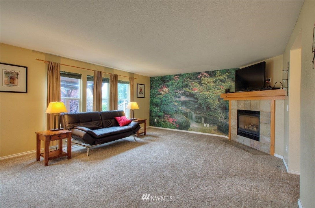 24425 101st Place Southeast Kent, WA 98030 - Photo 11 of 28 a living room with furniture a flat screen tv and a fireplace