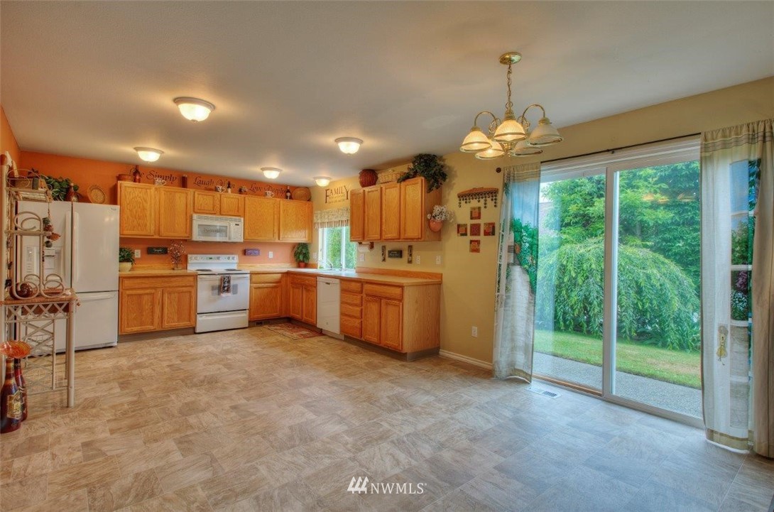 24425 101st Place Southeast Kent, WA 98030 - Photo 8 of 28 a kitchen with kitchen island a large counter top a sink appliances and cabinets
