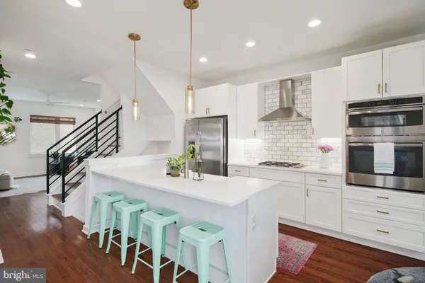a kitchen with stainless steel appliances kitchen island granite countertop a stove a sink and a refrigerator