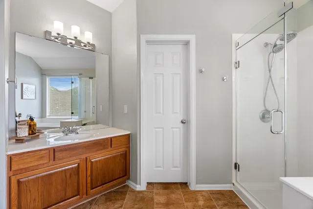 a bathroom with a double vanity sink mirror and shower