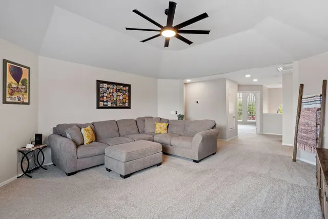 a living room with furniture and a ceiling fan