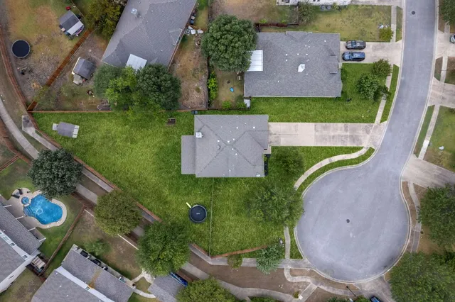 an aerial view of a house with a garden and swimming pool
