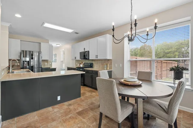 a kitchen with a dining table chairs and microwave