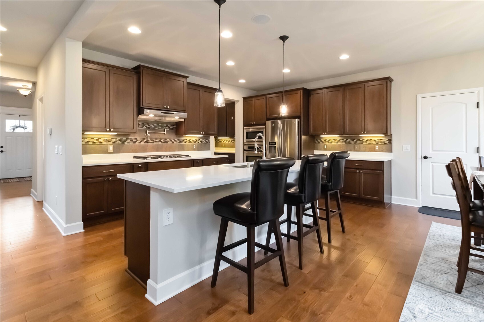 6721 Southeast 2nd Street Renton, WA 98059 - Photo 7 of 32 a kitchen with kitchen island a dining table and chairs