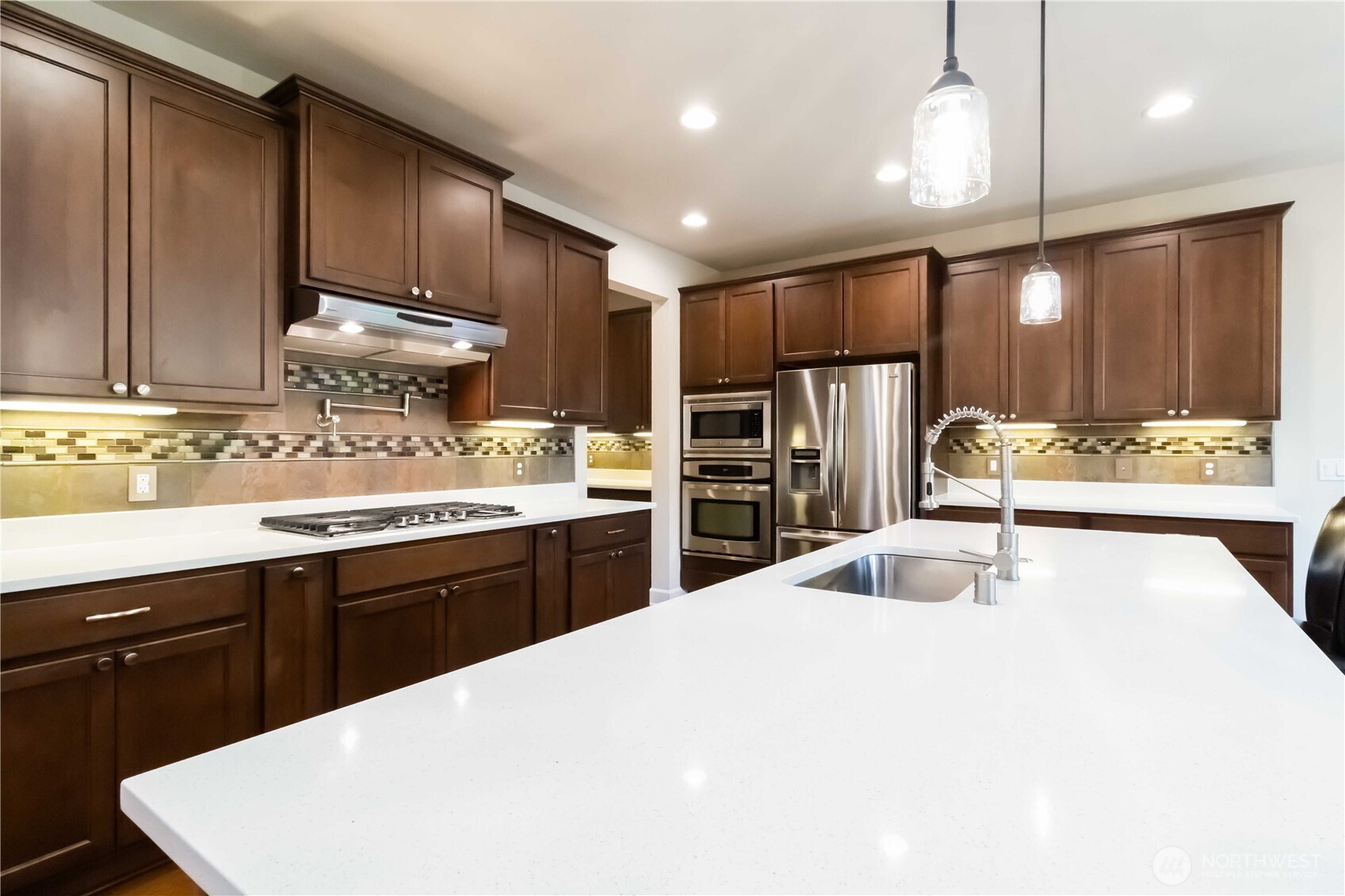 6721 Southeast 2nd Street Renton, WA 98059 - Photo 9 of 32 a kitchen with stainless steel appliances kitchen island granite countertop a sink stove and refrigerator
